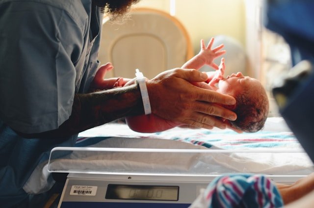 Mother holding her newborn while receiving supportive postpartum healthcare