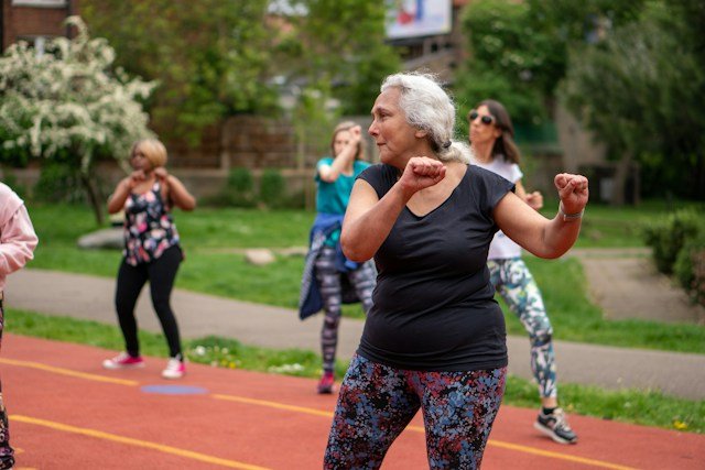 Older adults performing gentle seated and standing full-body exercises with professional guidance