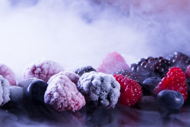 Recalled frozen blueberries and mixed berries in packages beside a freezer at home