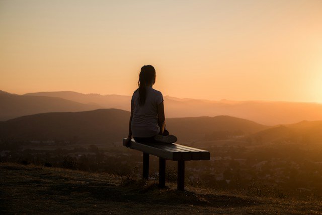 Person practicing quiet mindfulness meditation in a naturally lit room to manage everyday stress.