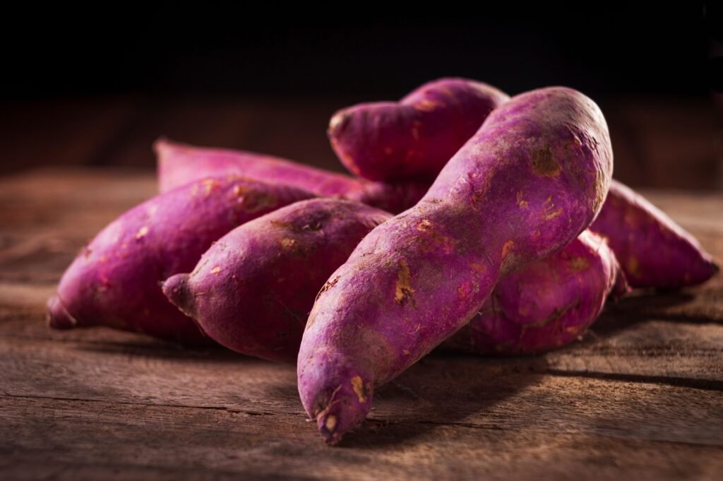 Older adult preparing colorful sweet potatoes and vegetables for a balanced healthy meal