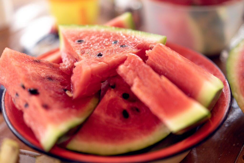 Roasted watermelon seeds beside fresh watermelon slices on a kitchen table