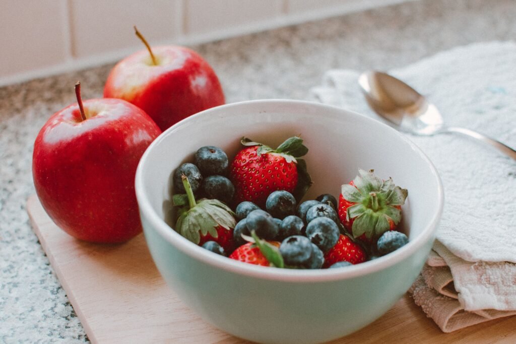 Colourful selection of berries, leafy greens, ginger, turmeric and other nutrient-rich foods associated with a balanced diet.