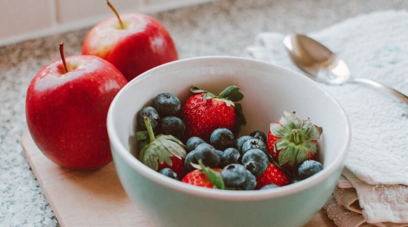 Colourful selection of berries, leafy greens, ginger, turmeric and other nutrient-rich foods associated with a balanced diet.