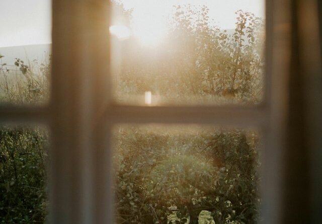 Older adult stepping outside into natural morning daylight during a peaceful daily walk