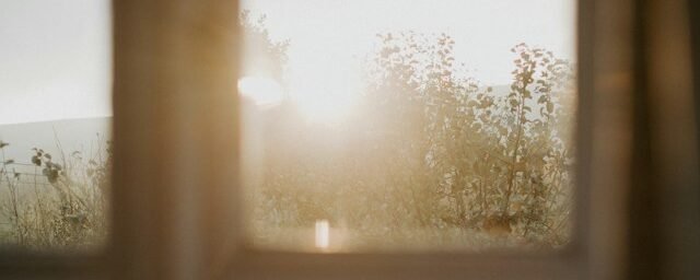 Older adult stepping outside into natural morning daylight during a peaceful daily walk