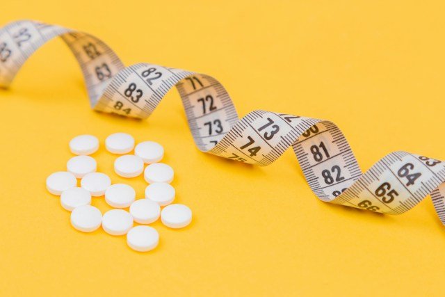 A healthcare professional discussing blood glucose results and metabolic health with an adult patient in a clinical setting.