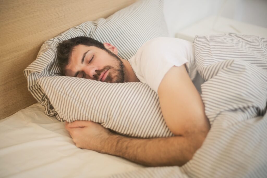 An adult resting comfortably on a sofa during a short afternoon nap in natural daylight.