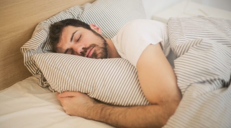 An adult resting comfortably on a sofa during a short afternoon nap in natural daylight.