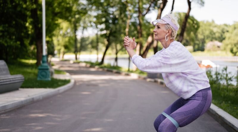 A woman performing a squat in a park, demonstrating axial loading and strength training for female bone health.