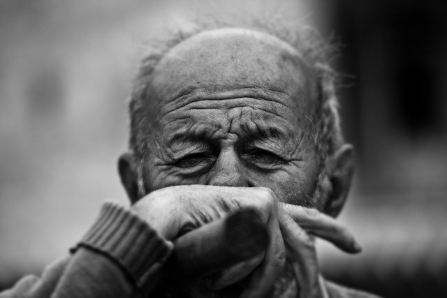 Older adult Alzheimer’s patient speaking with a healthcare professional during a neurological research assessment